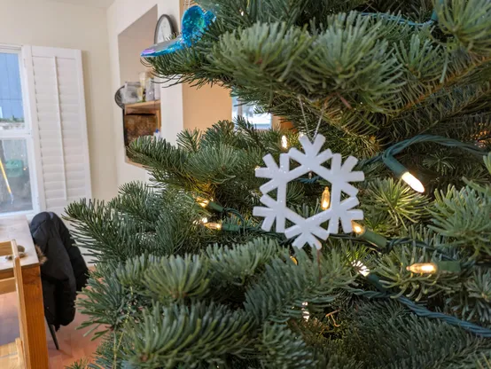 Snowflake Xmas tree ornament on a tree
