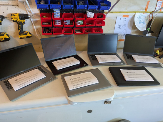 6 Dell latitudes lined up with printed nixbook guides on them