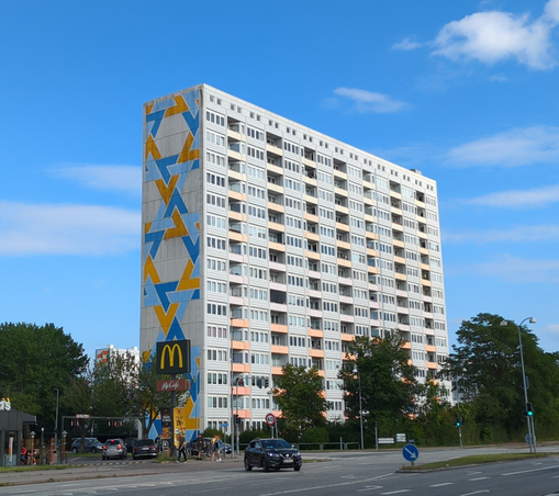 High building with a design on it's side without windows. The design shows multiple times a pattern which looks like the nixos logo.