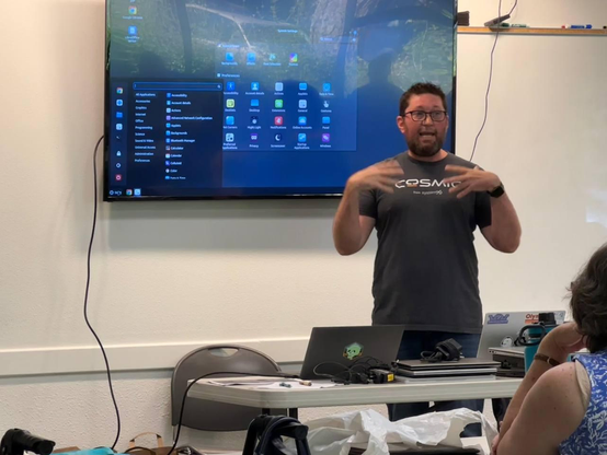 Nerd in a cosmic shirt with NixOS on display behind me giving a talk